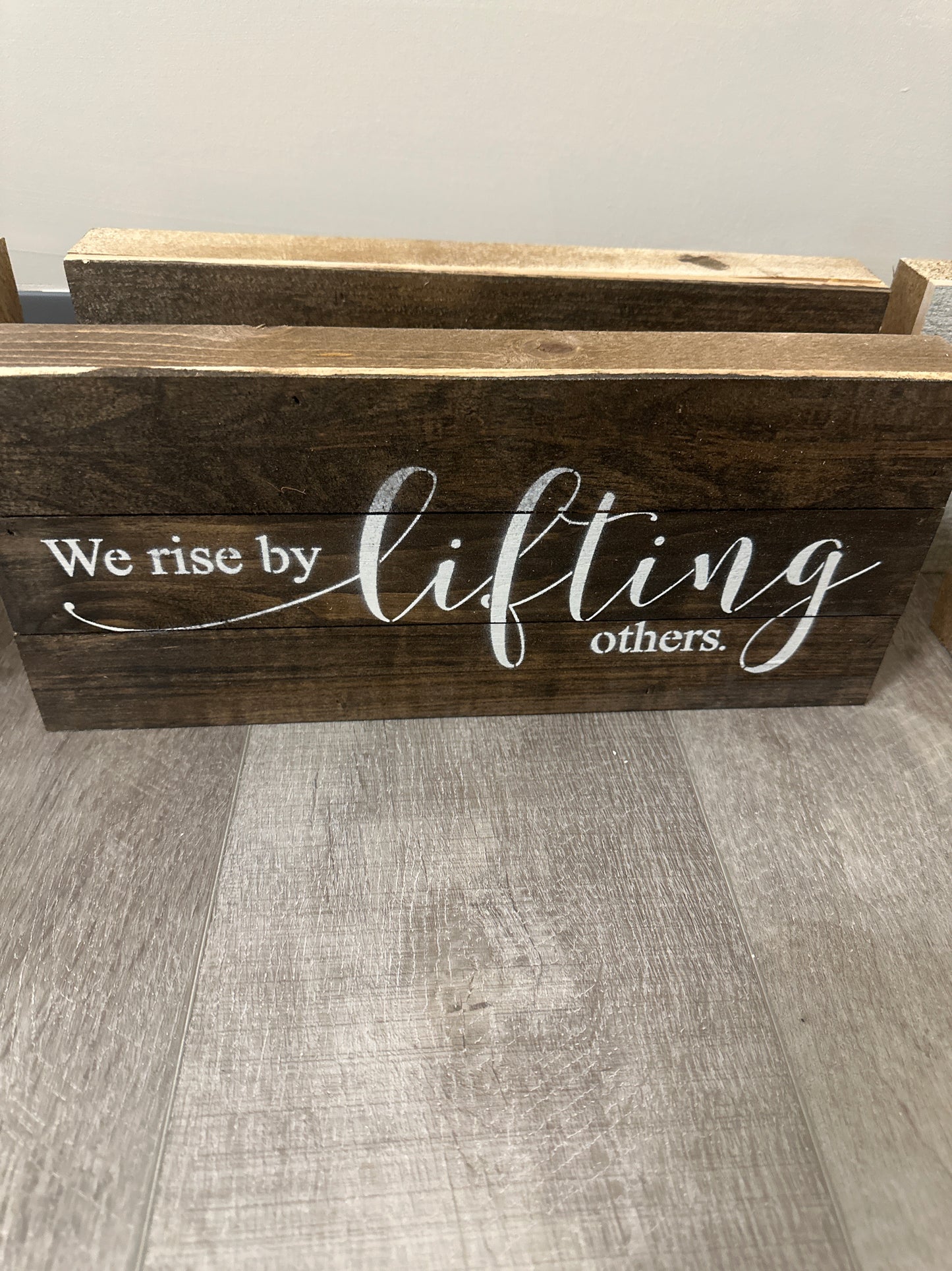 We rise by lifting others wood sign