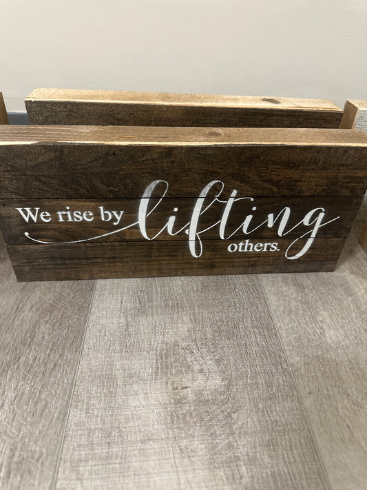 We rise by lifting others wood sign